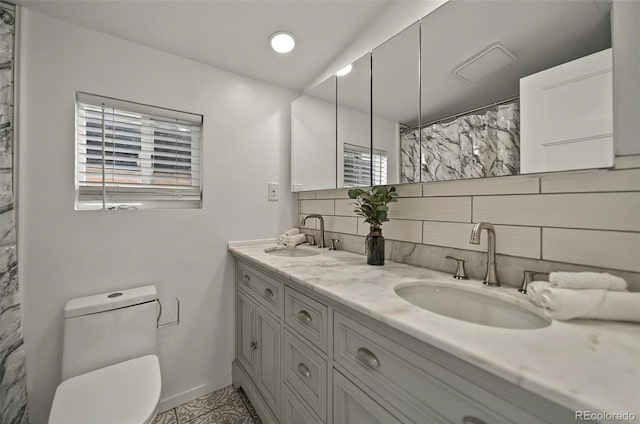 bathroom featuring baseboards, toilet, healthy amount of natural light, and decorative backsplash