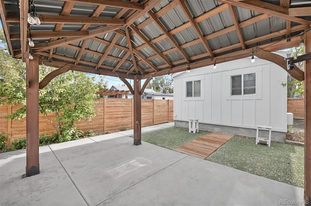 view of patio / terrace with fence, a gazebo, and an outbuilding