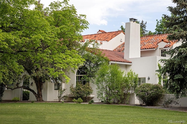 5800 E 6th Avenue Parkway, Denver, CO 80220 - back of house with a tile roof, a chimney, stucco siding, and a lawn