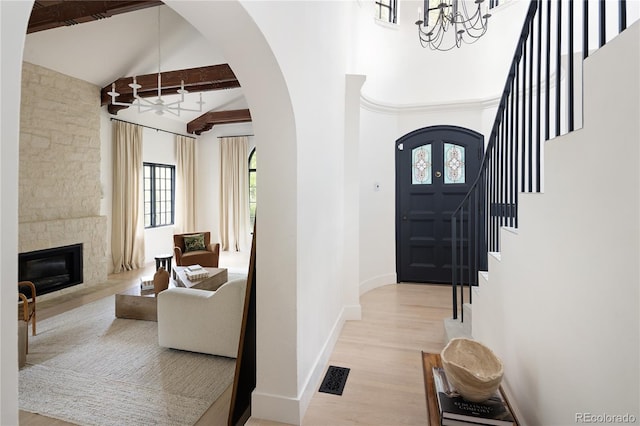 5800 E 6th Avenue Parkway, Denver, CO 80220 - foyer entrance featuring a chandelier, arched walkways, high vaulted ceiling, wood finished floors, and beamed ceiling