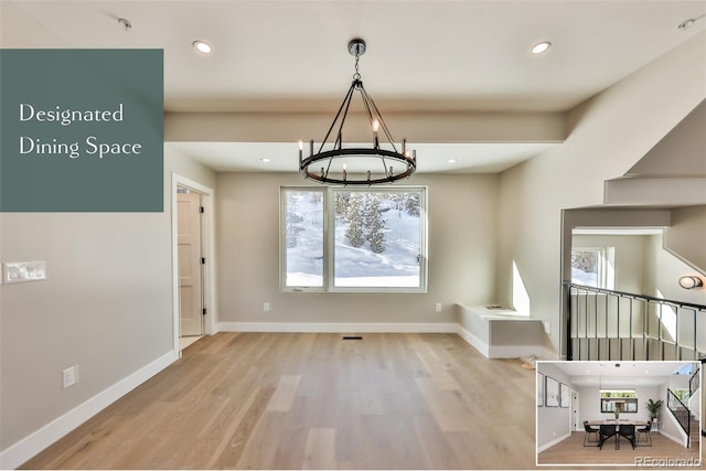 unfurnished dining area featuring a chandelier and light hardwood / wood-style flooring