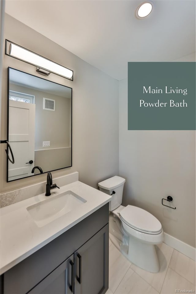 bathroom featuring tile patterned floors, vanity, and toilet