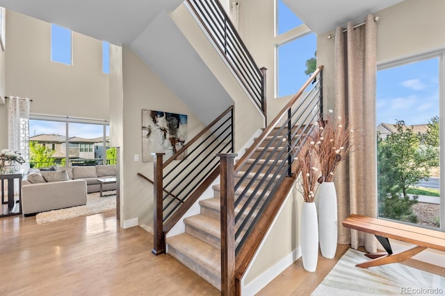 481 Meadowleaf Ln, Highlands Ranch, CO 80126 - staircase featuring a towering ceiling, plenty of natural light, wood finished floors, and baseboards
