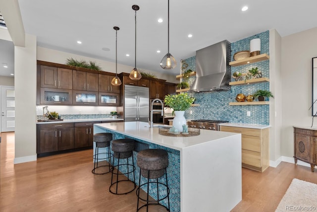481 Meadowleaf Ln, Highlands Ranch, CO 80126 - kitchen featuring stainless steel appliances, wall chimney range hood, a breakfast bar area, light countertops, and open shelves