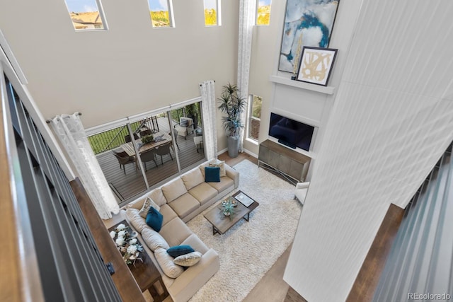 481 Meadowleaf Ln, Highlands Ranch, CO 80126 - living room featuring a towering ceiling, a glass covered fireplace, and wood finished floors