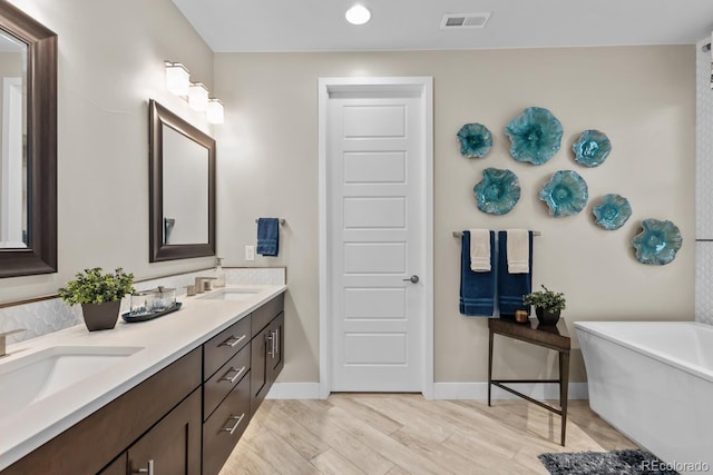 481 Meadowleaf Ln, Highlands Ranch, CO 80126 - bathroom with a freestanding bath, baseboards, double vanity, and wood finished floors
