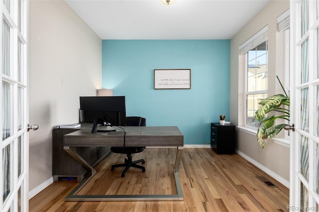 office with french doors, visible vents, baseboards, and wood finished floors