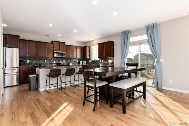 dining room featuring light wood-style flooring, baseboards, and recessed lighting