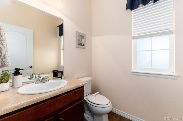 bathroom featuring toilet, tile patterned floors, baseboards, and vanity