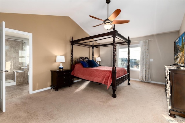 bedroom featuring lofted ceiling, ensuite bathroom, a ceiling fan, light carpet, and baseboards