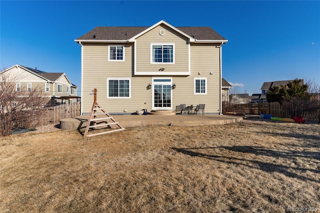 back of property featuring a fenced backyard, a patio, and a lawn