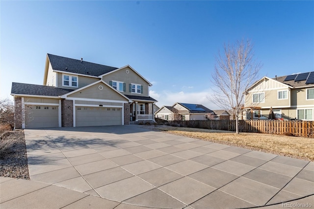 view of front of home with brick siding, concrete driveway, fence, a garage, and a residential view