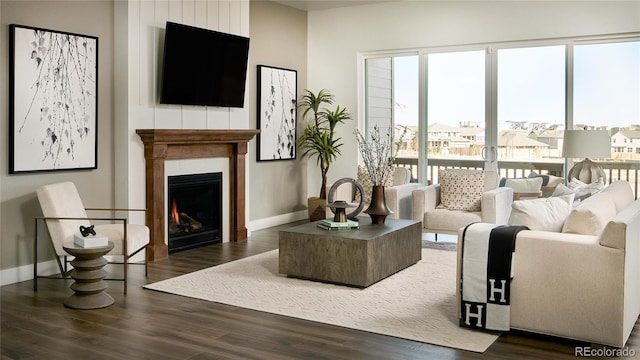 16500 Black Rose Cir, Parker, CO 80134 - living area with a warm lit fireplace, baseboards, and wood finished floors