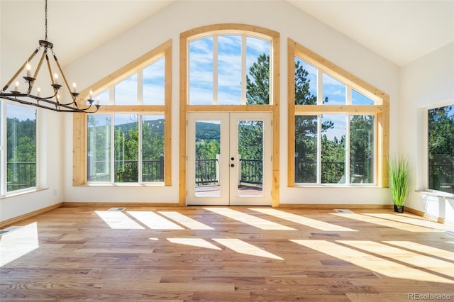 unfurnished sunroom featuring french doors, vaulted ceiling, and a chandelier