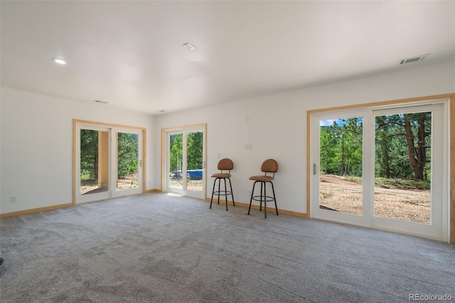 carpeted spare room featuring baseboards