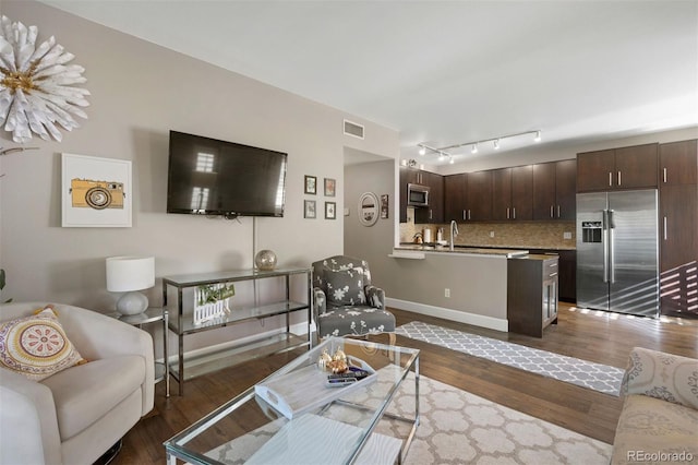 living room featuring dark hardwood / wood-style flooring and sink