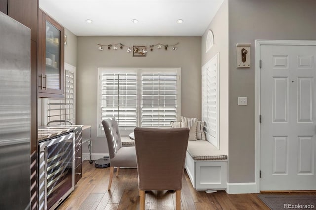 dining space with light hardwood / wood-style flooring and beverage cooler