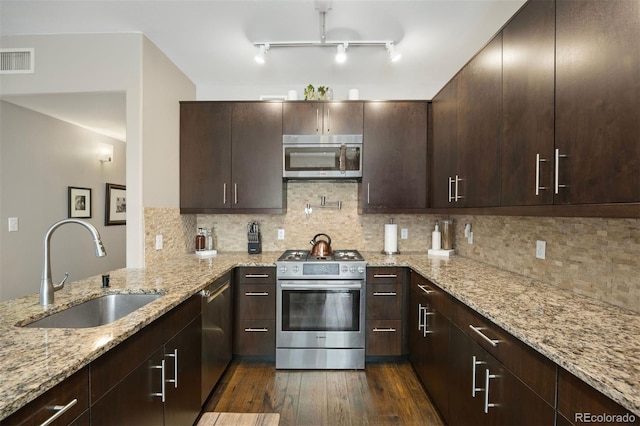 kitchen featuring stainless steel appliances, tasteful backsplash, sink, and light stone counters