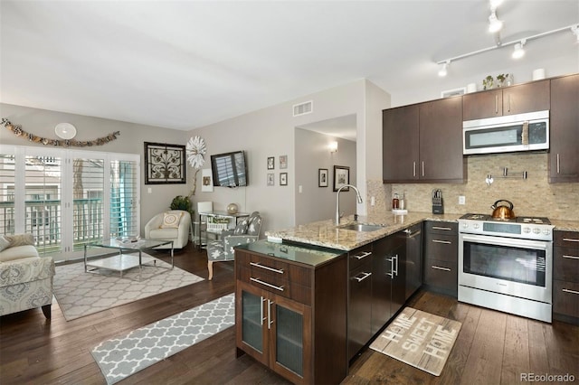 kitchen featuring sink, backsplash, dark brown cabinets, and stainless steel appliances