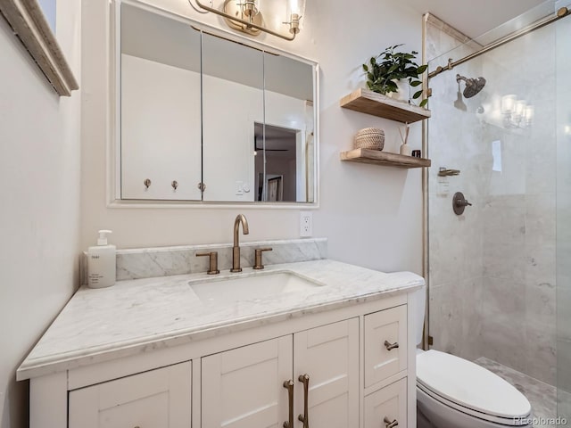 bathroom with a stall shower, vanity, and toilet