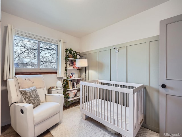 bedroom with a crib and a decorative wall