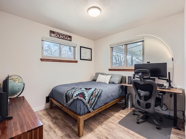 bedroom featuring baseboards and wood finished floors