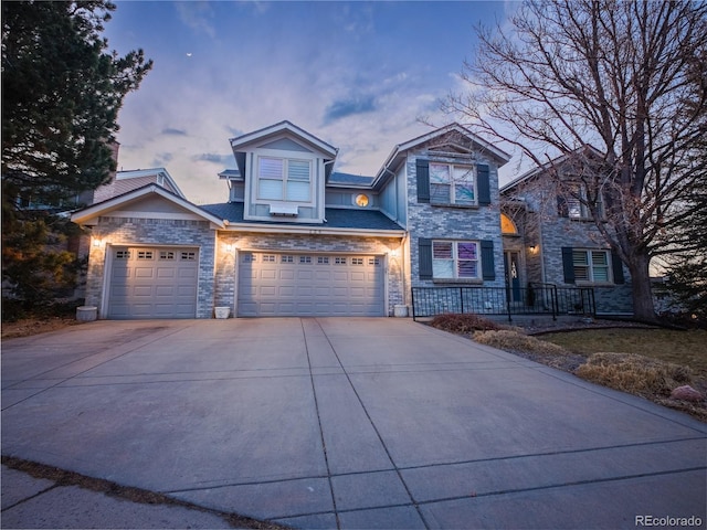 view of front of property with stone siding, concrete driveway, and a garage