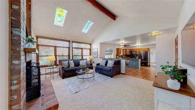 941 E 130th Cir, Thornton, CO 80241 - living area with high vaulted ceiling, beamed ceiling, a fireplace, a skylight, and light carpet
