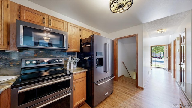 941 E 130th Cir, Thornton, CO 80241 - kitchen with stainless steel appliances, backsplash, light wood-type flooring, and light countertops