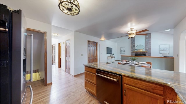 941 E 130th Cir, Thornton, CO 80241 - kitchen featuring dishwashing machine, light wood finished floors, ceiling fan, and brown cabinetry