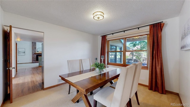 941 E 130th Cir, Thornton, CO 80241 - dining space with a textured ceiling, light carpet, and a brick fireplace