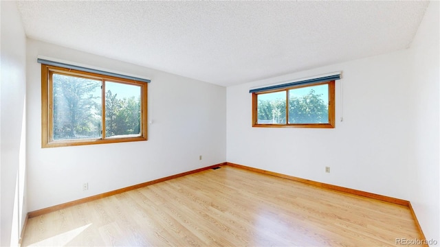 941 E 130th Cir, Thornton, CO 80241 - spare room featuring plenty of natural light, wood finished floors, and a textured ceiling