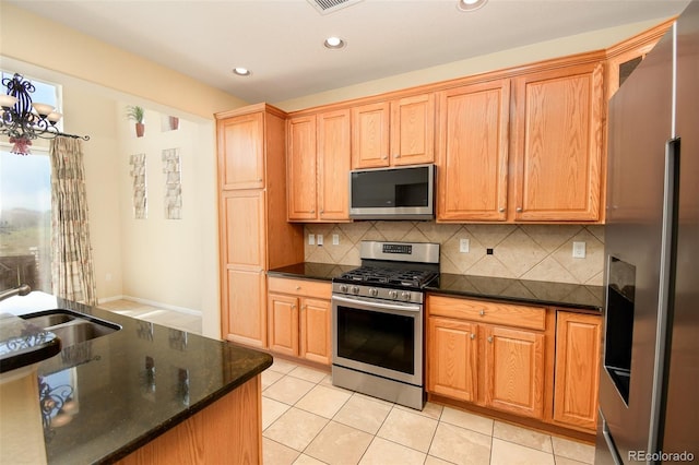 10597 Ashfield St, Highlands Ranch, CO 80126 - kitchen featuring appliances with stainless steel finishes, light tile patterned floors, backsplash, recessed lighting, and dark stone counters