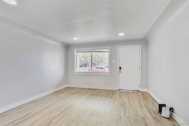 empty room with baseboards, wood finished floors, and recessed lighting