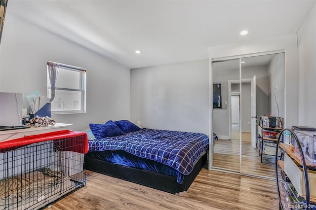 bedroom featuring recessed lighting, wood finished floors, and a closet