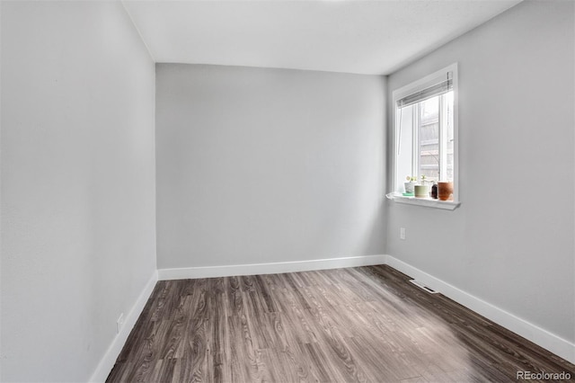 unfurnished room with wood finished floors and baseboards