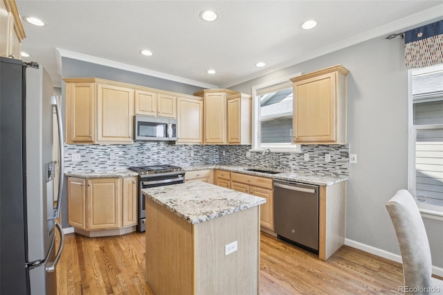 kitchen featuring appliances with stainless steel finishes, light brown cabinetry, a sink, ornamental molding, and backsplash