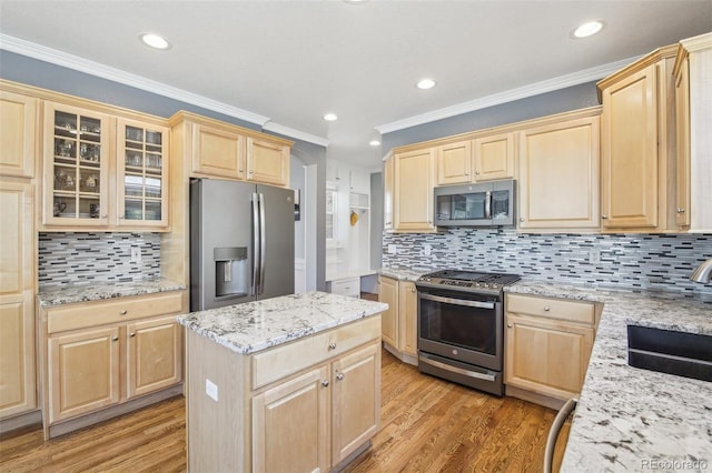 kitchen featuring appliances with stainless steel finishes, light brown cabinets, a sink, light wood-style flooring, and recessed lighting