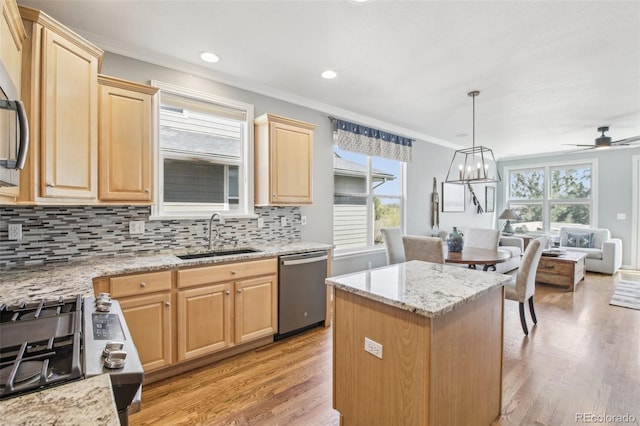 kitchen featuring a sink, light brown cabinetry, ornamental molding, appliances with stainless steel finishes, and light wood finished floors