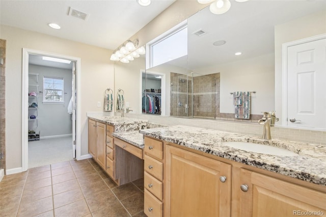 bathroom featuring a shower stall, vanity, tile patterned flooring, a walk in closet, and baseboards