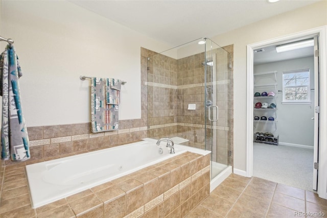 full bathroom featuring a stall shower, a bath, tile patterned floors, and a spacious closet