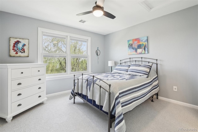 bedroom with light carpet, baseboards, and attic access
