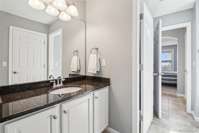 bathroom featuring vanity, baseboards, and tile patterned flooring