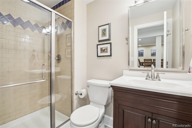 bathroom featuring a stall shower, toilet, and vanity