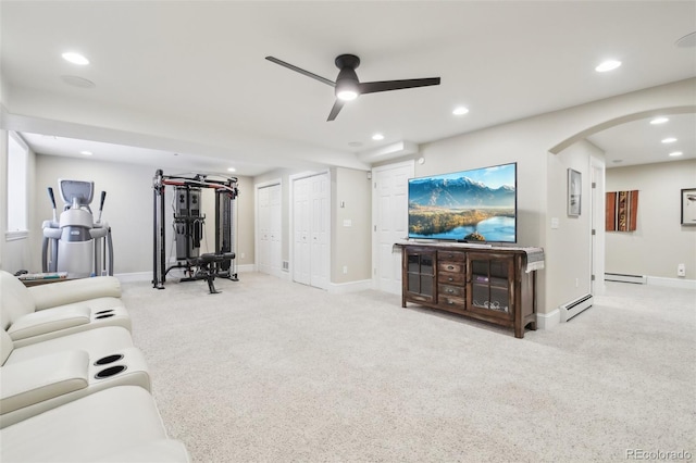 workout area featuring carpet flooring, arched walkways, baseboard heating, a ceiling fan, and recessed lighting
