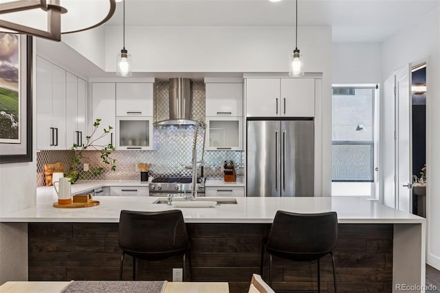 3036 Wilson Ct Unit 5, Denver, CO 80205 - kitchen featuring high end fridge, wall chimney range hood, light countertops, modern cabinets, and tasteful backsplash