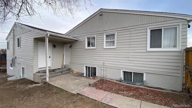 back of property with entry steps and fence