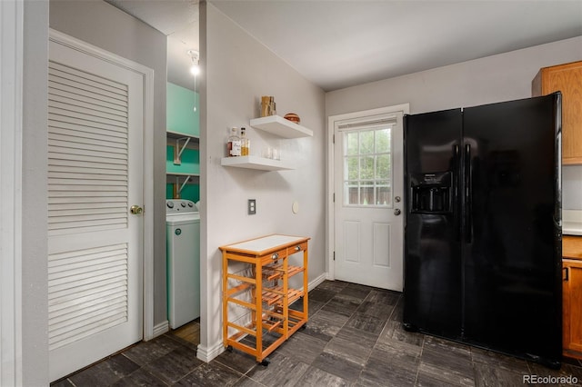 kitchen featuring black fridge and washer / clothes dryer