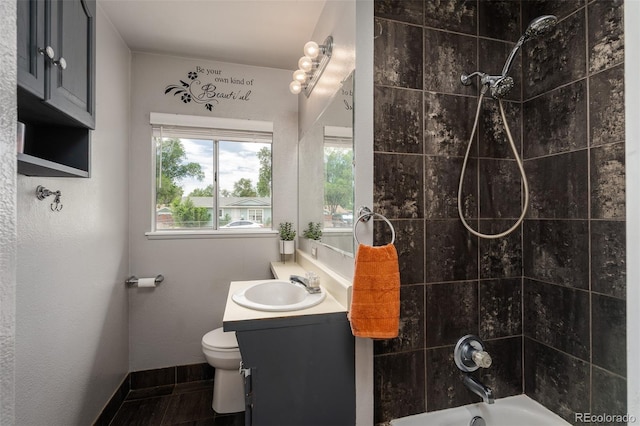 full bathroom featuring vanity, toilet, tiled shower / bath, and tile patterned flooring