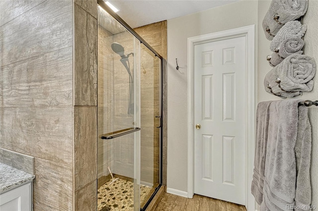 bathroom featuring hardwood / wood-style flooring and a shower with door